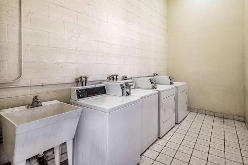 a laundry room with three washing machines and a sink at Motel 6-Gardena, CA - South in Gardena