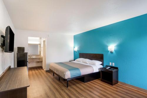 a bedroom with a bed and a blue wall at Motel 6-Lexington, KY - Airport in Lexington