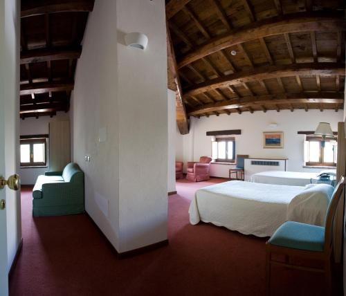 a bedroom with a bed and chairs in a room at Dimora della Fonte in Greccio