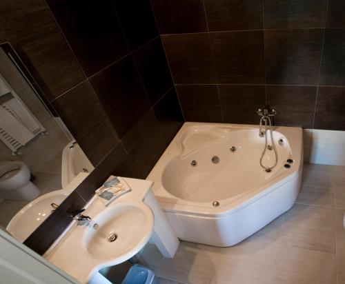 een badkamer met een bad, een wastafel en een toilet bij Dimora della Fonte in Greccio
