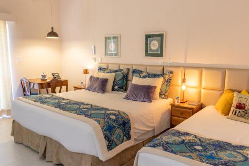 a bedroom with two beds and a table and chairs at Locanda della Mimosa in Itaipava