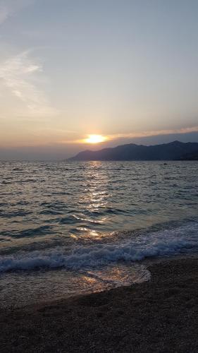 a sunset on the beach with the sun setting at Magic Stone Apartments in Baška Voda