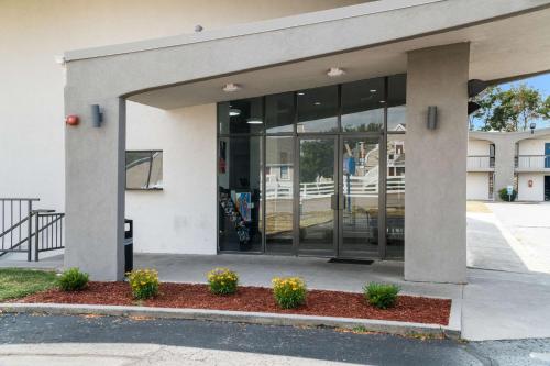 a building with glass doors and flowers in front at Motel 6-Lexington, KY - Airport in Lexington