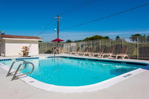a small swimming pool with chairs and a fence at Motel 6-Longview, TX in Longview