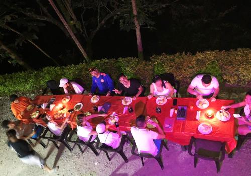 a group of people sitting around a table at night at Termales el Escondite in Florencia