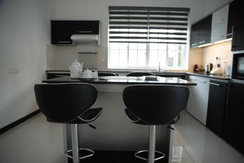a kitchen with two black chairs and a kitchen counter at White Castle in Wadduwa