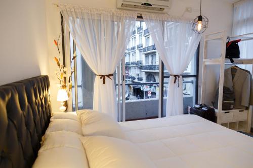 een slaapkamer met een bed en een groot raam bij Departamento Buenos Aires Centro in Buenos Aires