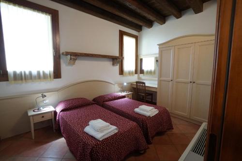 1 dormitorio con 1 cama con 2 toallas en Apartment 1 Rosmarino 2 bedroom, en Vicenza