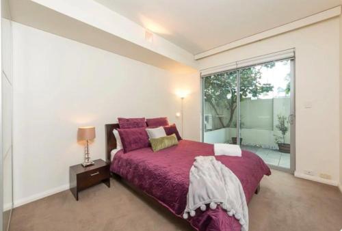 a bedroom with a large bed and a large window at TRANQUIL EXEC CITY FREE WIFI NETFLIX WINE PARKING in Perth