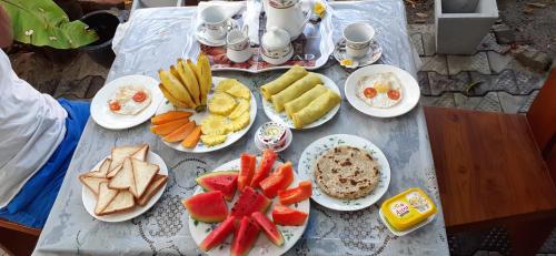 una mesa con platos de comida y fruta. en Bisandu guesthouse en Mirissa