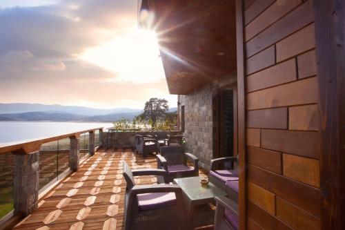 a deck with chairs and tables and a view of the water at RELAX Guest House in Tsigov Chark