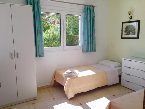 a bedroom with two beds and two windows at Villa Sikia in Katokhórion