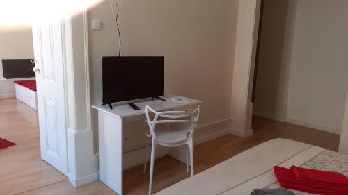 Cette chambre dispose d'une télévision, d'un bureau et d'une chaise. dans l'établissement Sweet Love Family I, à Coimbra