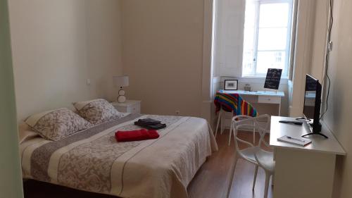 a bedroom with a bed and a desk with a computer at Sweet Love Family I in Coimbra