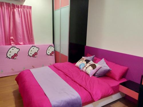 ein Schlafzimmer mit einem rosa Bett und Hello-Kitty-Kissen in der Unterkunft WindMill SunRise PaddyView Homestay in Sekinchan