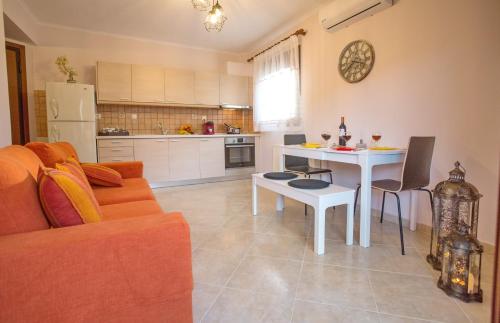 a living room with a couch and a table at Konstantina & Evgenia Deluxe Apartment in Nea Peramos