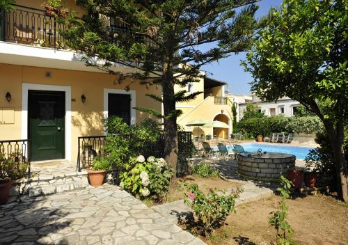 ein Haus mit einem Baum und einem Pool in der Unterkunft Ariti Apartments in Kassiopi