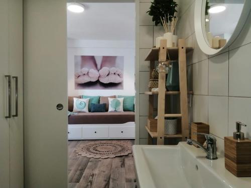 łazienka z umywalką, lustrem i kanapą w obiekcie Estudio Pies de Arena w mieście Mijas Costa