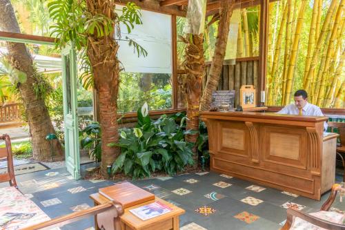 a man sitting at a podium in a room with trees at Locanda della Mimosa in Itaipava