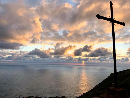a cross on top of a hill near the water at Tramonto sul Mare in Framura