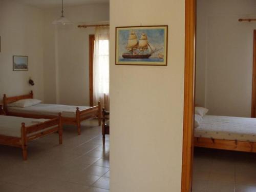 a room with two beds and a painting of a ship at Kombi Beach in Kómboi