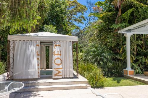 a gazebo with a white canopy in a yard at Locanda della Mimosa in Itaipava