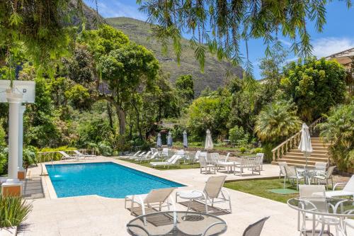 a resort with a pool and chairs and trees at Locanda della Mimosa in Itaipava