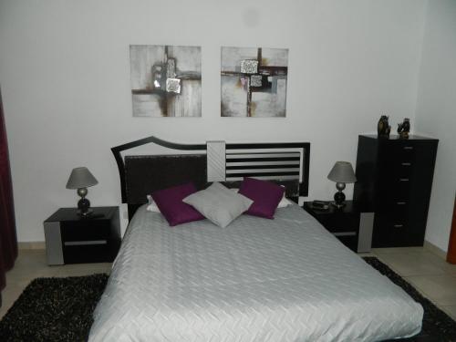 a bedroom with a bed with purple and white pillows at Casa da Piedade in Piedade