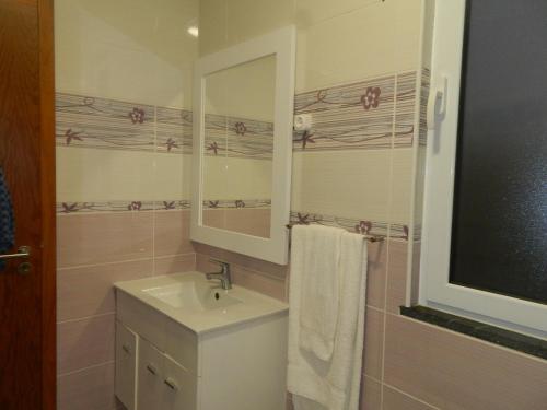 W łazience znajduje się umywalka i lustro. w obiekcie Casa da Piedade w mieście Piedade