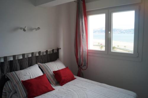 エンプリアブラバにあるParaiso Mar y Solのベッドルーム1室(赤い枕2つ、窓付)