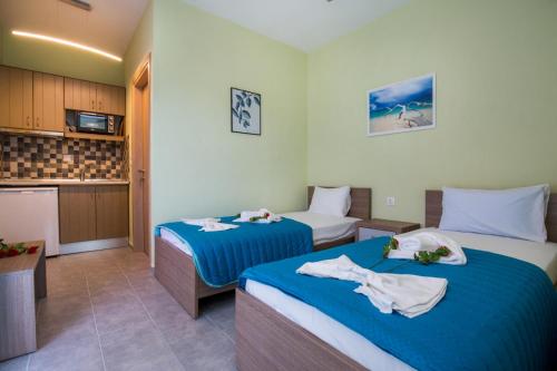 a hotel room with two beds and a kitchen at Studios Koula 2 - KORINA in Potos