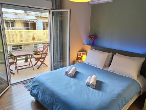 雅典的住宿－Renovated apartment close to Exarchia square，一间卧室配有蓝色的床和2条毛巾