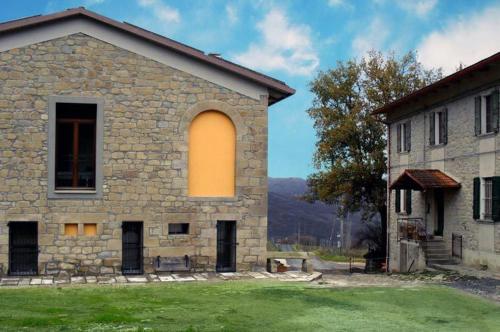 a large stone building with a large window on it at Agriturismo I Fondacci in Grizzana