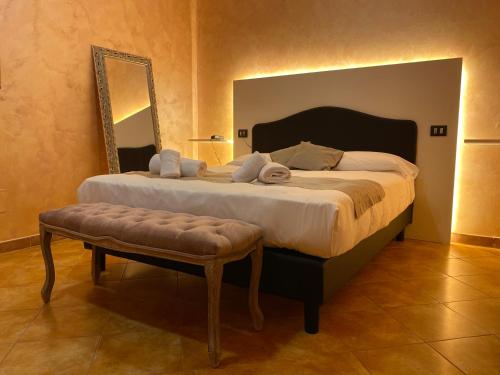 a bedroom with a large bed with a bench and a mirror at Impero Hotel Beauty & Spa - Bike Hotel in Cantello