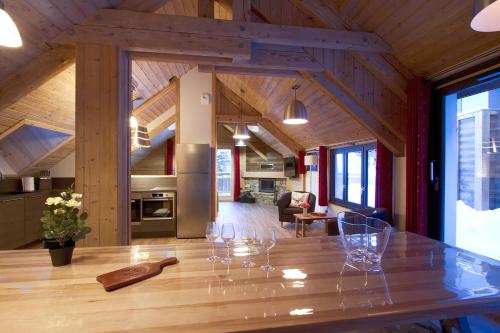 - une salle à manger avec une table et des verres à vin dans l'établissement Chalet Le Challenge - Les 2 Alpes, à Mont-de-Lans
