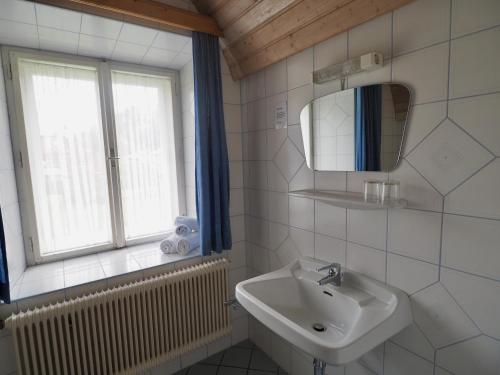 Baño blanco con lavabo y espejo en Gasthof Zum Grünen Specht, en Oberzeiring