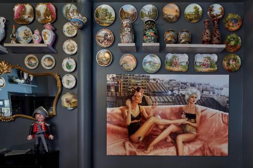 a wall with a picture of two women sitting on a couch at Hôtel de Roubaix in Paris