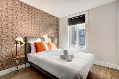 a bedroom with a large bed with orange pillows at Burgundy Lofts - Marché Atwater in Montréal