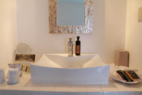 un lavandino bianco in un bagno con specchio di Mykonos Resort Miura / Vacation STAY 62208 a Yokosuka