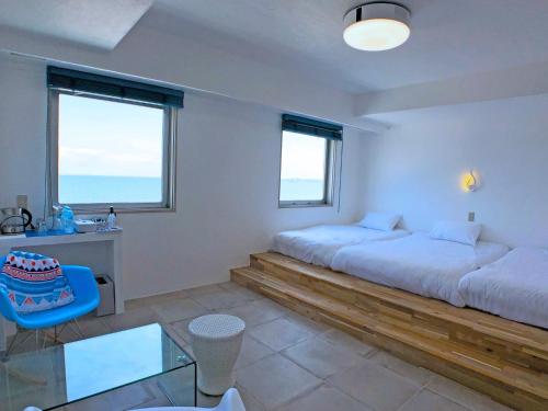 a bedroom with two beds and a desk and two windows at Mykonos Resort Miura / Vacation STAY 62208 in Yokosuka