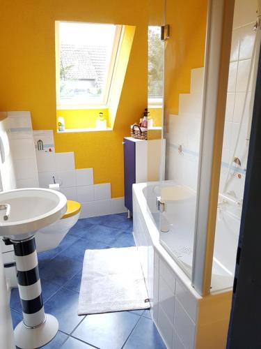 a yellow bathroom with a sink and a toilet at Ferienwohnung Kochel mit Wallbox in Gifhorn