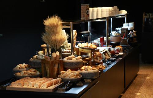 a buffet line with various types of bread and pastries at Mercure Belo Horizonte Lourdes in Belo Horizonte