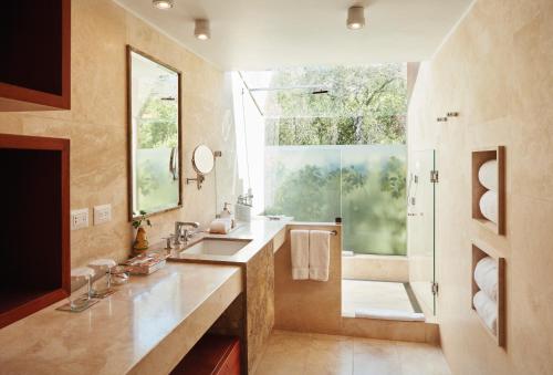 a bathroom with a sink and a shower with a window at Rio Sagrado, A Belmond Hotel, Sacred Valley in Urubamba