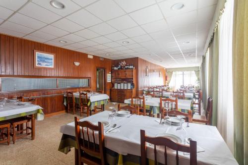 a dining room with tables and chairs in a restaurant at Hotel Canaima Bruma 1,5 k Camino in O Mesón Do Vento 