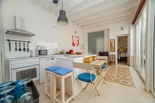 una cocina con encimeras blancas, mesa y sillas en Theodora Chica 1, en Málaga