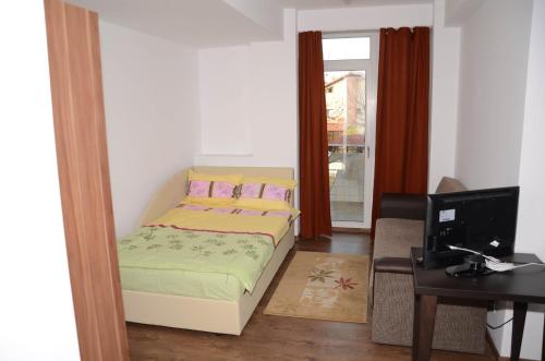 a small bedroom with a bed and a desk at Apart La Cave in Bucharest