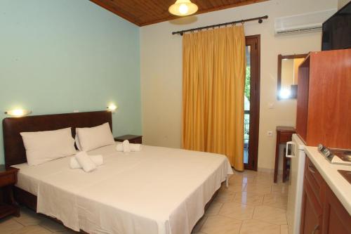 a bedroom with a large white bed and a window at Vicky Apartments in Nikiana