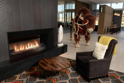 a living room with a fireplace and a horse statue at Hyatt Place Pena Station/Denver Airport in Denver