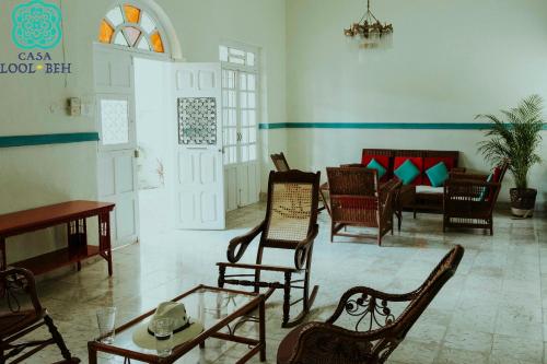 a living room with chairs and a table and a room with at Casa Lool Beh in Mérida