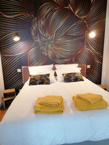 une chambre avec un lit blanc avec deux serviettes dessus dans l'établissement Le 43-4 avec sauna privatif, au Puy-en-Velay